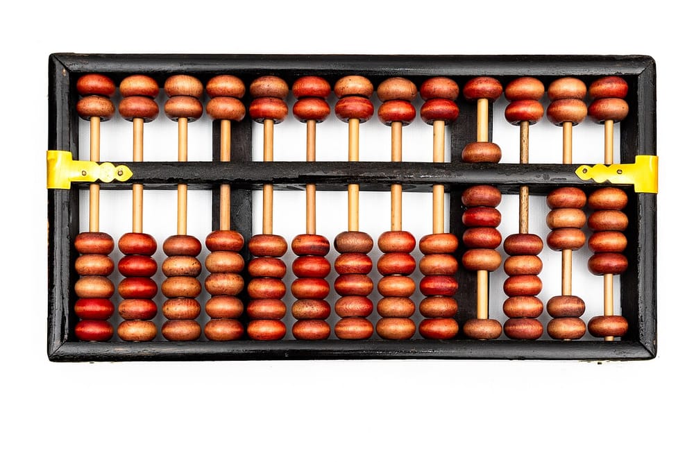 A Chinese abacus: wooden beads on thin rods in a frame, with a bar across that divides them.